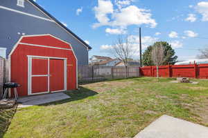 View of yard with a fenced backyard, a storage unit, and an outdoor structure