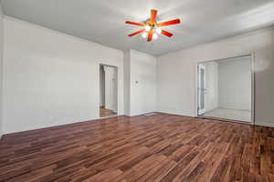 Interior space with baseboards, wood finished floors, ornamental molding, and ceiling fan