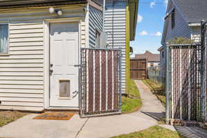 View of exterior entry featuring fence and a gate