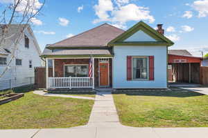 Bungalow-style house with a front yard, a porch, fence, and a chimney