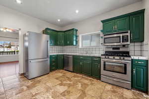 Kitchen with tile countertops, green cabinetry, and stainless steel appliances