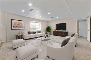 Carpeted living room featuring visible vents, baseboards, and recessed lighting