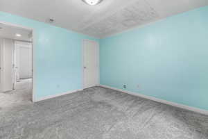 Spare room featuring visible vents, baseboards, and carpet