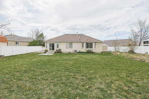 Back of house with central air condition unit, stucco siding, entry steps, a fenced backyard, and a yard