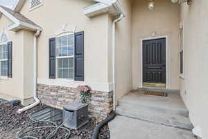 Entrance to property featuring stucco siding and stone siding