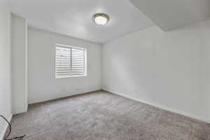 Carpeted empty room featuring baseboards
