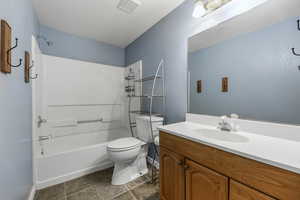 Full bathroom featuring shower / washtub combination, vanity, visible vents, toilet, and baseboards