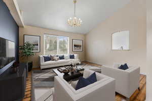 Living room featuring baseboards, wood finished floors, a chandelier, and vaulted ceiling