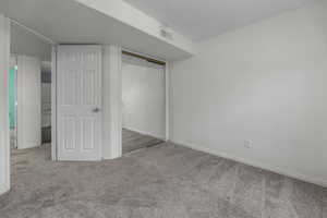 Unfurnished bedroom featuring a closet, visible vents, baseboards, and carpet floors