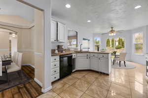 Kitchen with plenty of natural light, a peninsula, a sink, and black dishwasher