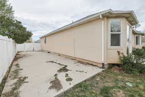 View of side of home featuring a RV pad, fence, a gate, and stucco siding