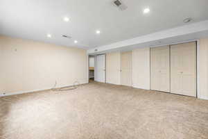 Interior space featuring visible vents, baseboards, recessed lighting, and carpet flooring
