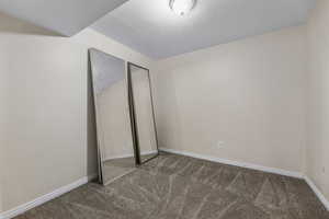 Unfurnished bedroom featuring baseboards and carpet floors