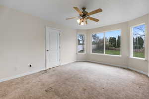Unfurnished room with carpet, visible vents, baseboards, and ceiling fan