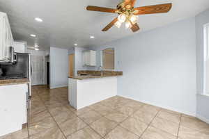 Kitchen featuring stone countertops, recessed lighting, white cabinetry, and a ceiling fan