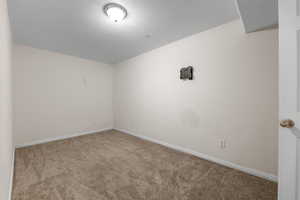 Carpeted spare room with baseboards