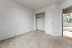 Unfurnished bedroom featuring a closet, baseboards, and carpet