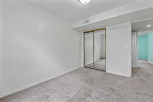 Unfurnished bedroom featuring carpet flooring, visible vents, a closet, and baseboards