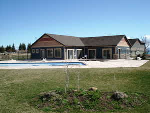 View of pool featuring a patio area, a fenced in pool, fence, and a lawn