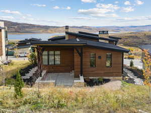 Rear view of property with a chimney and a mountain view