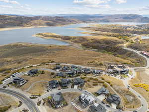 Aerial view of property's location with a water and mountain view and nearby suburban area