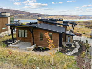 Rear view of house with a chimney, a mountain view, and a metal roof
