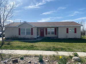Single story home featuring a front lawn