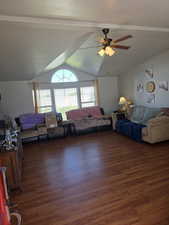 Living room featuring ceiling fan, wood finished floors, and vaulted ceiling