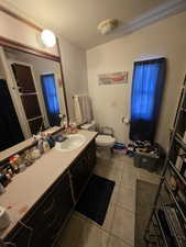 Bathroom with a textured ceiling, tile patterned floors, toilet, and vanity