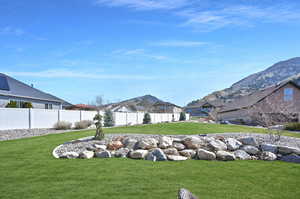 View of yard with a residential view, fence, and a mountain view