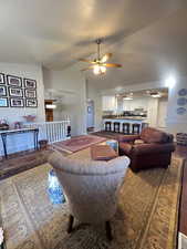 Living area with high vaulted ceiling, hardwood floors.