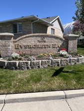 Community / neighborhood sign featuring a yard and a mountain view