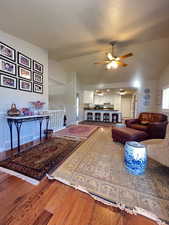 Living area with hardwood flooring, and vaulted ceiling.