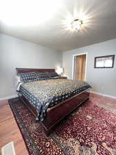 Primary bedroom with en suite and hardwood flooring.