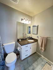 Guest Bath with shower over tub and granite vanity countertop.