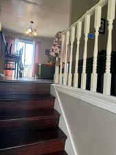 Staircase featuring a chandelier