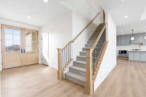 Foyer with recessed lighting, stairway, light wood-style flooring, and french doors