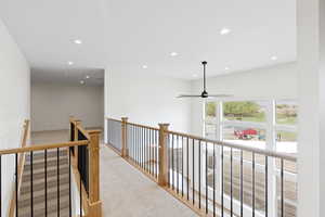 Corridor featuring light colored carpet, an upstairs landing, and recessed lighting