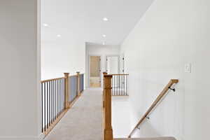 Corridor with recessed lighting, an upstairs landing, baseboards, and carpet