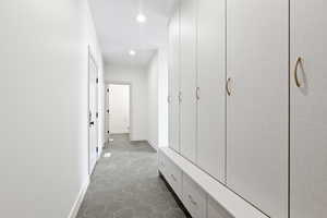 Hall featuring dark tile patterned flooring, baseboards, and recessed lighting