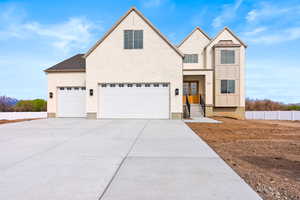 View of front of home featuring board and batten siding, a garage, roof with shingles, fence, and concrete driveway