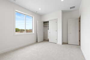Unfurnished bedroom with baseboards, visible vents, and carpet floors