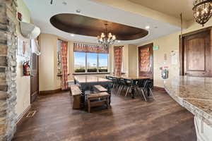 Dining room with visible vents, baseboards, an inviting chandelier, and dark wood finished floors