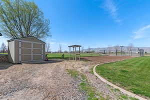 View of yard featuring a storage shed, an outbuilding, and a mountain view