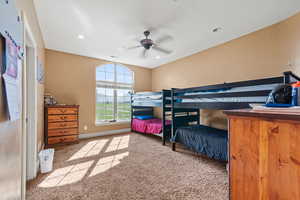 Carpeted bedroom featuring ceiling fan, baseboards, visible vents, and recessed lighting