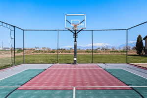 View of sport court featuring a yard and basketball court