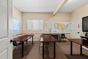 Office area featuring beamed ceiling, baseboards, and carpet