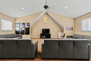 Carpeted living room with recessed lighting, lofted ceiling, baseboards, and ceiling fan