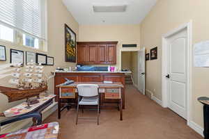 Home office with light carpet and baseboards
