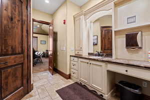 Bathroom featuring recessed lighting, vanity, stone tile floors, and baseboards
